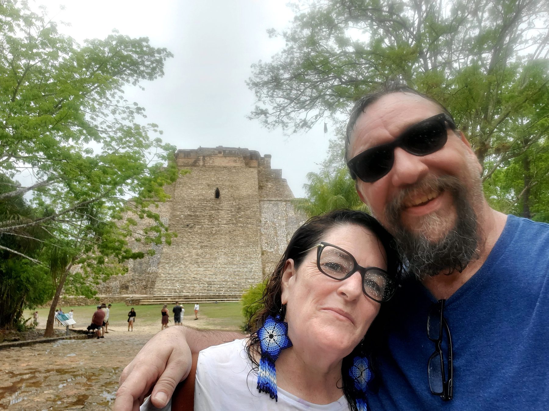 Micah Owens and his wife in front of a stone temple on a rainy day